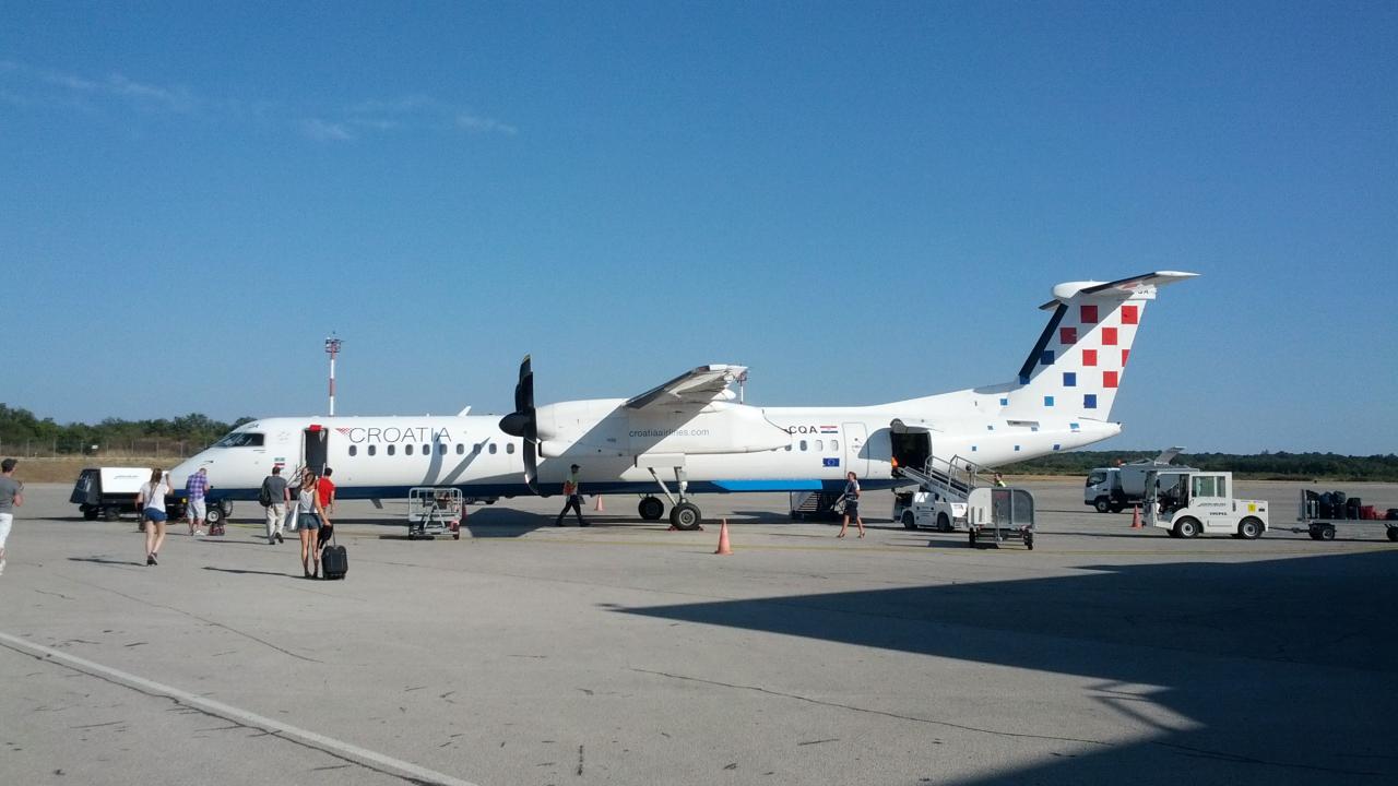 Airplane of the Croatian Airlines in the airport in Pula while passengers boarding