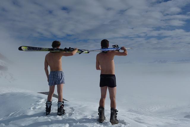 Two skiers in underpants with skis in their hands